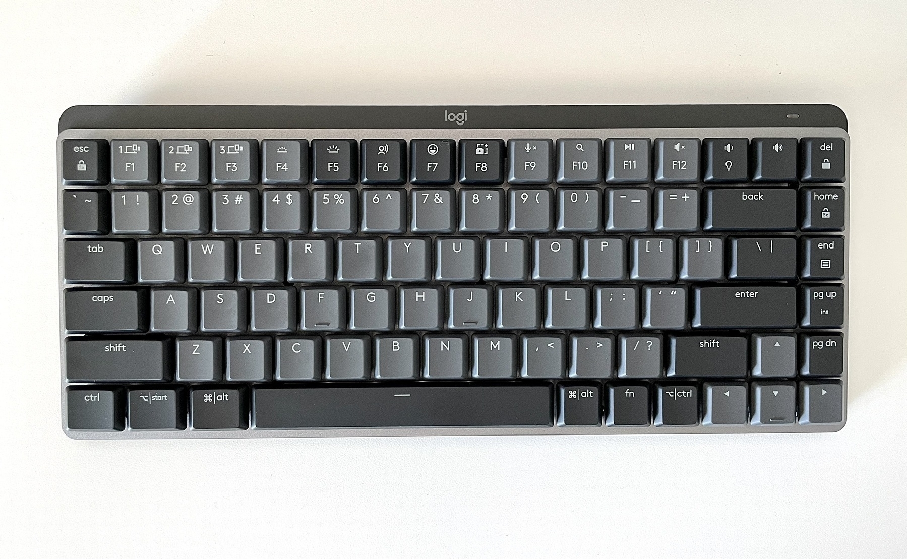 A top-down photo of a Logitech MX Mechanical Mini keyboard on a white desktop.
